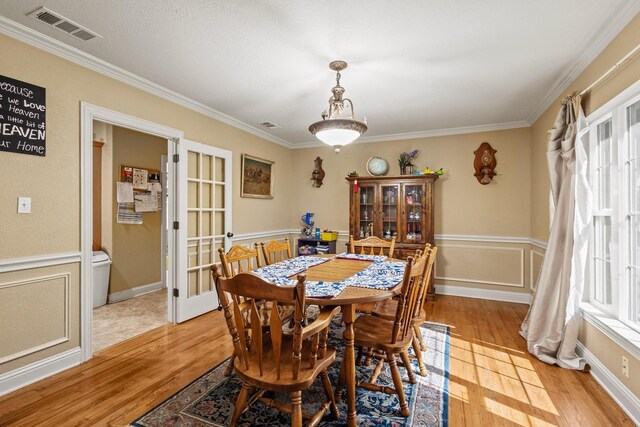 dining area featuring crown molding, visible vents, and light wood-type flooring