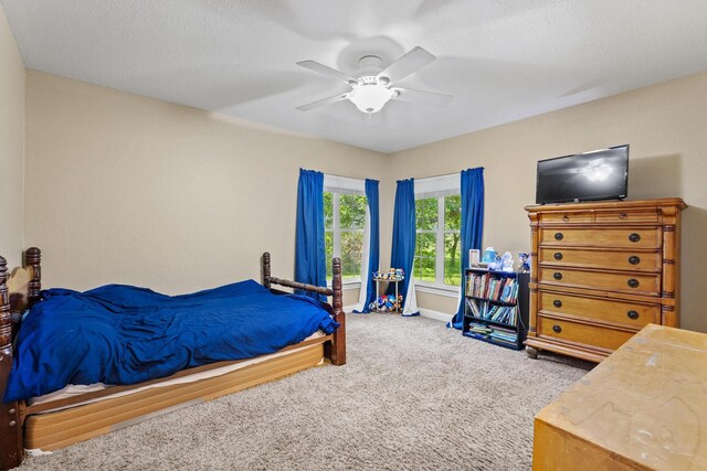carpeted bedroom with baseboards and a ceiling fan