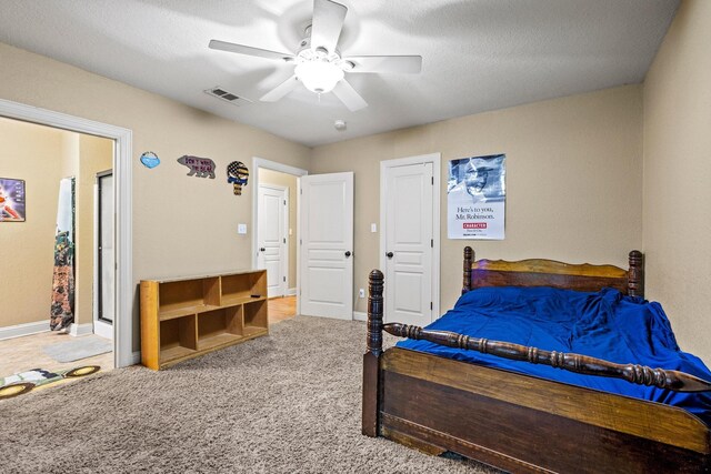 carpeted bedroom with visible vents, baseboards, and ceiling fan