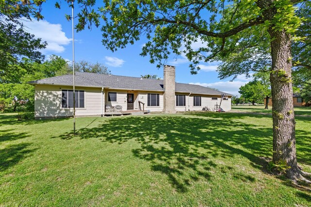 back of property featuring a lawn and a chimney