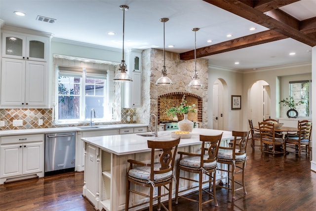 kitchen with light countertops, visible vents, decorative backsplash, stainless steel dishwasher, and a sink
