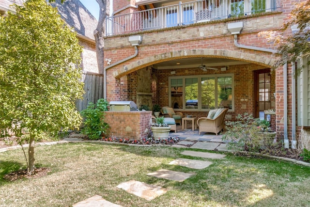 exterior space featuring exterior kitchen, a patio area, ceiling fan, and brick siding