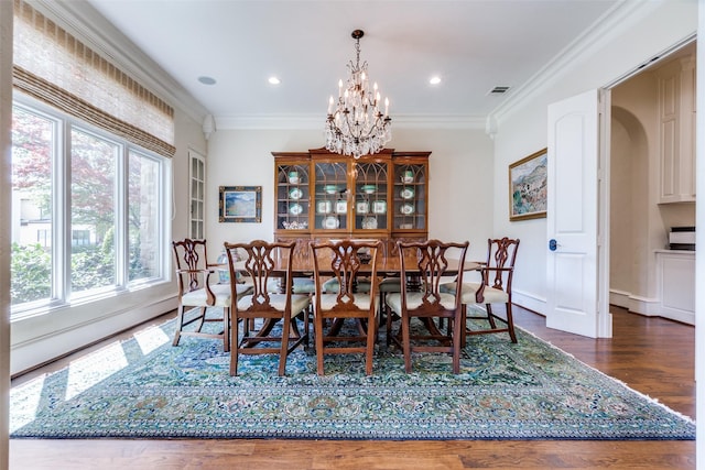 dining room featuring crown molding, visible vents, a notable chandelier, and wood finished floors
