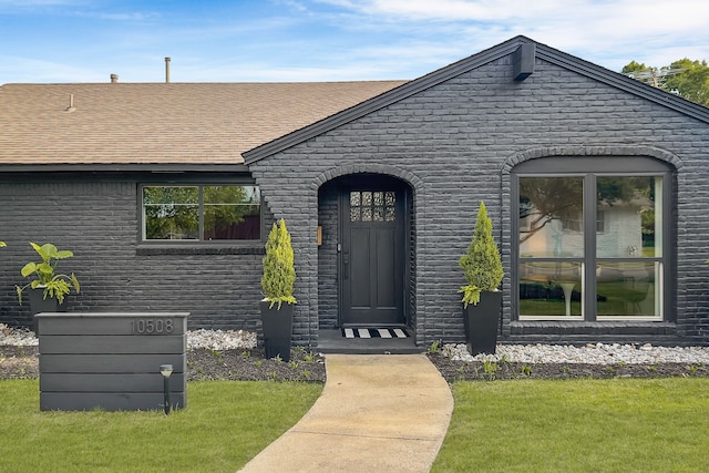 view of exterior entry featuring a yard