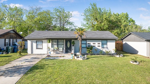 single story home featuring a shingled roof, concrete driveway, and a front yard