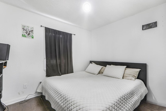 bedroom featuring wood finished floors and baseboards