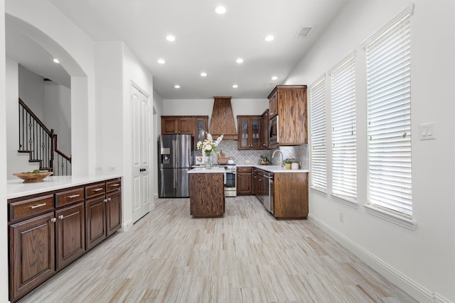 1208 Claire St, Lantana, TX 76226 - kitchen with stainless steel appliances, custom exhaust hood, recessed lighting, a kitchen island, and arched walkways