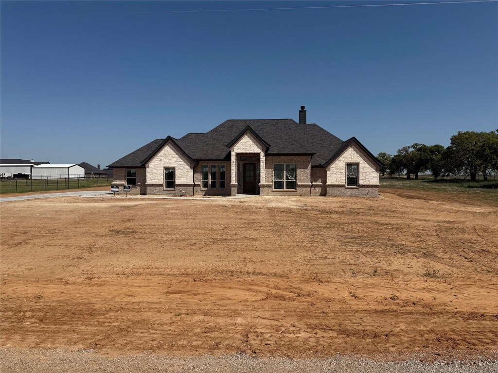 1991 Johnnie Dr, Springtown, TX 76082 - modern farmhouse with roof with shingles, a chimney, stone siding, and fence