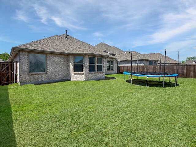 3906 Greenbrier Dr, Melissa, TX 75454 - rear view of property with a yard, a fenced backyard, a trampoline, and brick siding