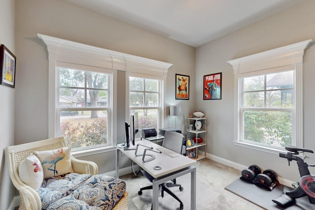 home office with healthy amount of natural light, light colored carpet, and baseboards