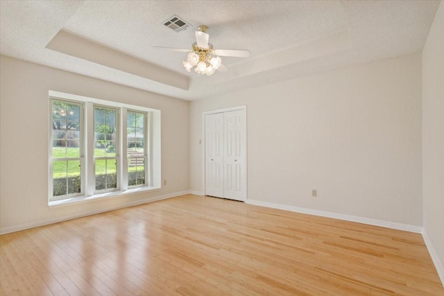 10010 Lost Oak Ridge Dr, Woodway, TX 76712 - spare room with a tray ceiling, light wood finished floors, a ceiling fan, baseboards, and a textured ceiling