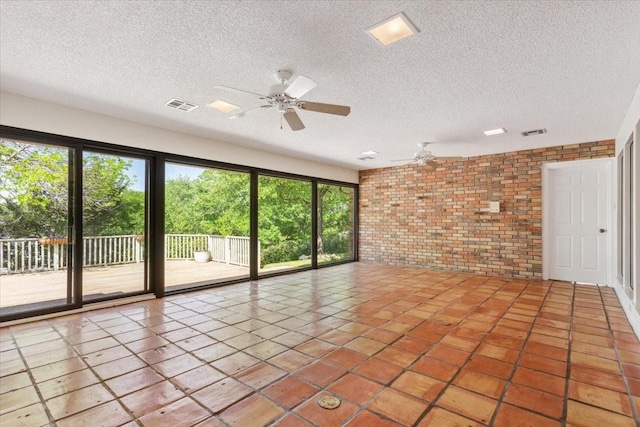 10010 Lost Oak Ridge Dr, Woodway, TX 76712 - tiled empty room featuring brick wall, a ceiling fan, a textured ceiling, and healthy amount of natural light
