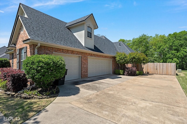 106 Horseguards Ave, Bossier City, LA 71111 - view of home's exterior with fence, roof with shingles, brick siding, concrete driveway, and an attached garage