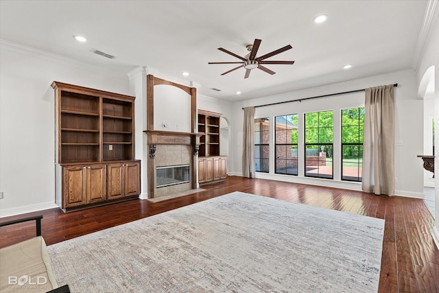 106 Horseguards Ave, Bossier City, LA 71111 - unfurnished living room featuring a ceiling fan, dark wood-style flooring, a tiled fireplace, crown molding, and baseboards