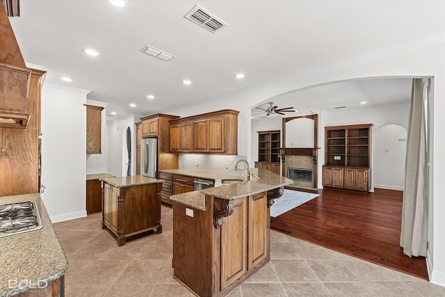 106 Horseguards Ave, Bossier City, LA 71111 - kitchen featuring visible vents, a ceiling fan, a peninsula, arched walkways, and stainless steel appliances
