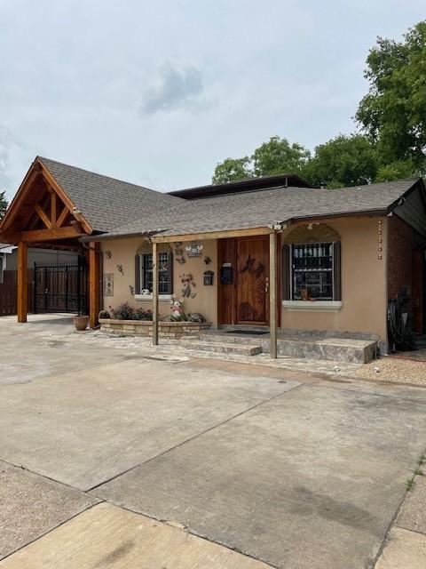 3915 Mather Ct, Dallas, TX 75211 - view of front of home with stucco siding, roof with shingles, and driveway