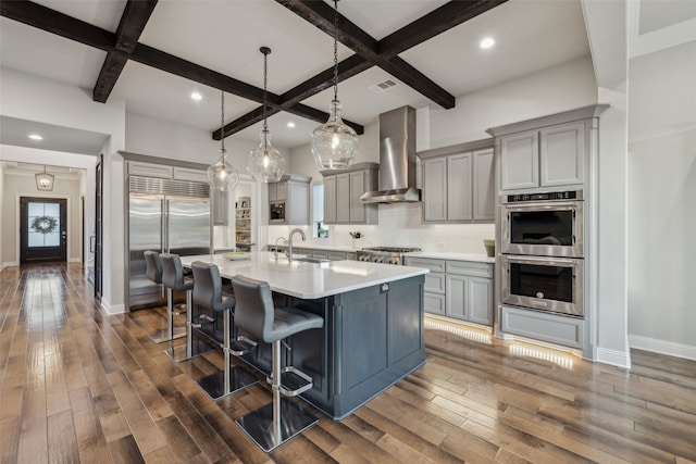 781 Star Meadow Dr, Prosper, TX 75078 - kitchen featuring wall chimney range hood, appliances with stainless steel finishes, a sink, coffered ceiling, and gray cabinetry