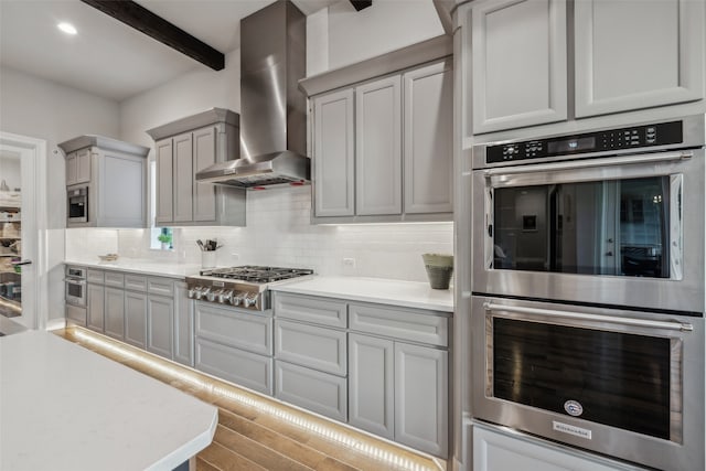 781 Star Meadow Dr, Prosper, TX 75078 - kitchen with wall chimney range hood, light countertops, appliances with stainless steel finishes, wood finished floors, and decorative backsplash