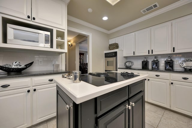 kitchen featuring stainless steel appliances, tasteful backsplash, visible vents, and white cabinets