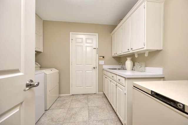 clothes washing area with baseboards, separate washer and dryer, a sink, and cabinet space