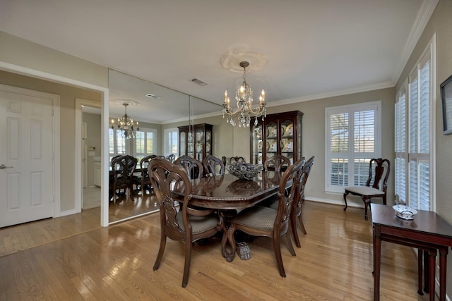 dining area with light wood finished floors, an inviting chandelier, baseboards, and visible vents