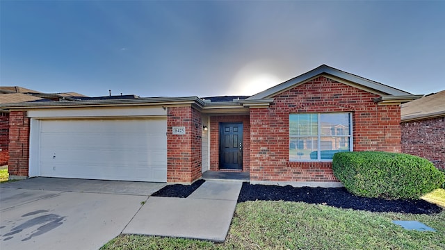 ranch-style home with a garage, brick siding, and driveway