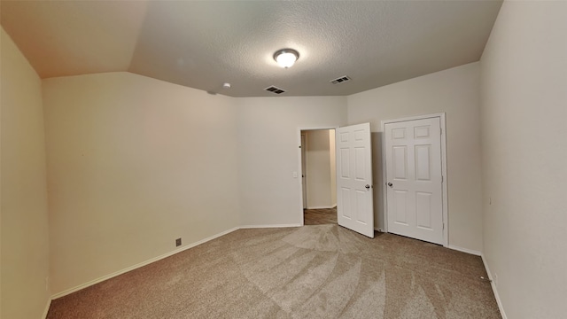 unfurnished bedroom featuring carpet flooring, visible vents, a textured ceiling, and baseboards