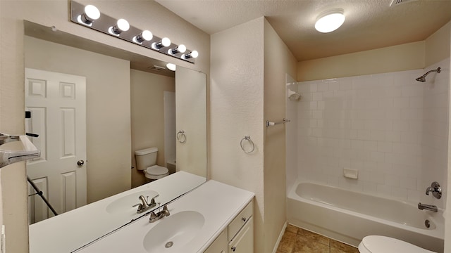 full bath featuring vanity, tile patterned floors, a textured ceiling, toilet, and shower / bathtub combination
