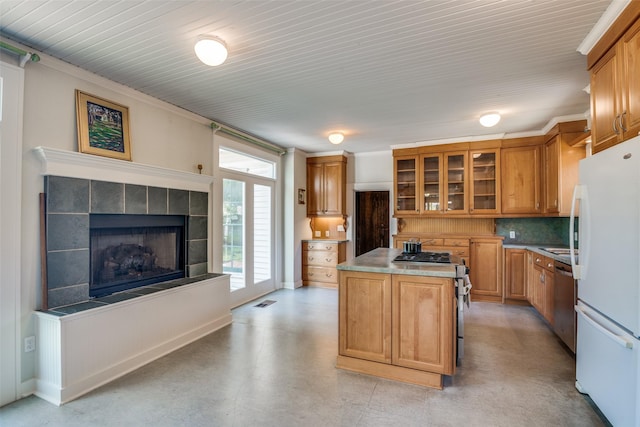 401 Pacific Ave, Terrell, TX 75160 - kitchen with glass insert cabinets, a kitchen island, light countertops, stainless steel appliances, and decorative backsplash