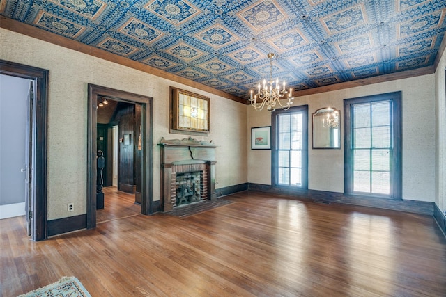 401 Pacific Ave, Terrell, TX 75160 - unfurnished living room featuring an ornate ceiling, a brick fireplace, an inviting chandelier, and wood finished floors