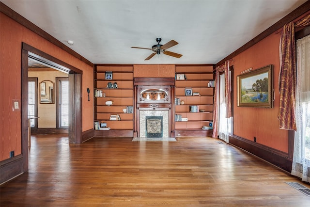 401 Pacific Ave, Terrell, TX 75160 - unfurnished living room featuring visible vents, a large fireplace, a ceiling fan, and wood finished floors