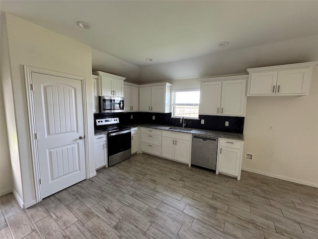 3409 Sandstone Dr, Sherman, TX 75092 - kitchen featuring appliances with stainless steel finishes, white cabinetry, tasteful backsplash, light wood-style floors, and recessed lighting