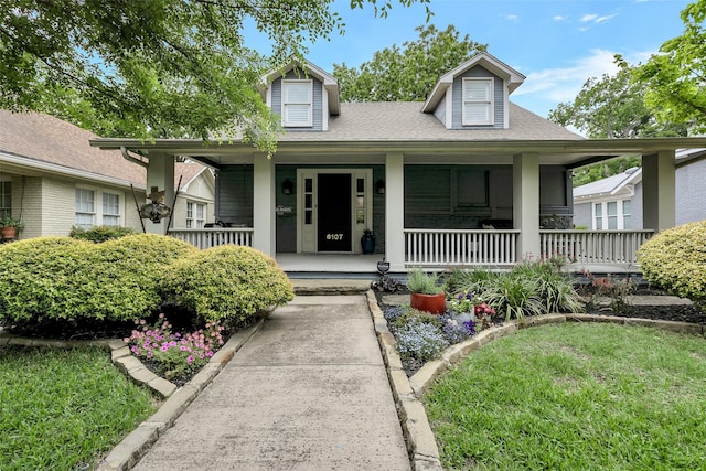 view of front of home with covered porch and a shingled roof