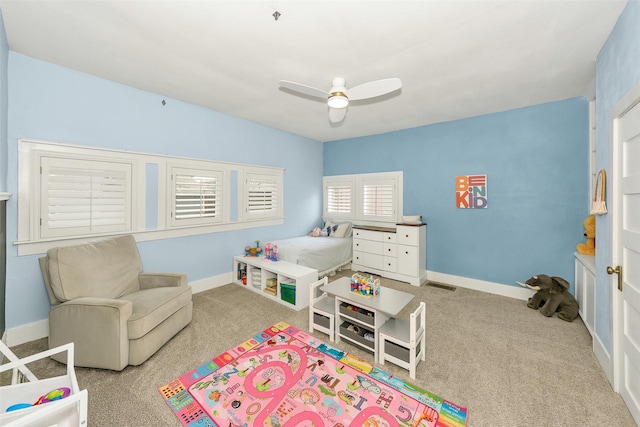carpeted bedroom with baseboards, a ceiling fan, and visible vents