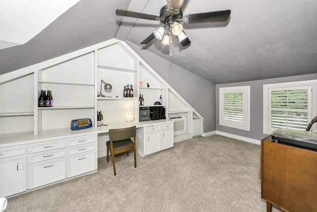 office featuring built in study area, ceiling fan, light carpet, and lofted ceiling