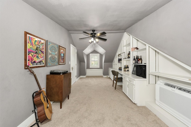 office area featuring light colored carpet, a ceiling fan, baseboards, and vaulted ceiling