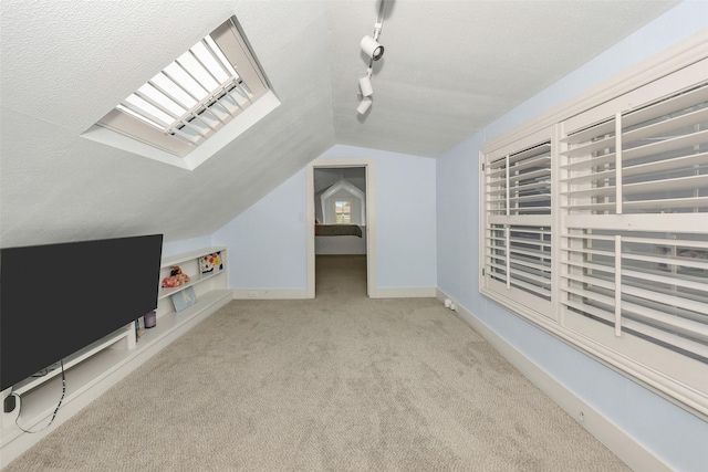 bonus room with carpet floors, a textured ceiling, baseboards, and lofted ceiling