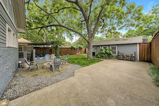view of yard with a fenced backyard, a patio area, and an outdoor fire pit