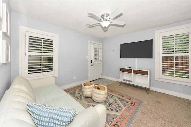 carpeted living area featuring baseboards and ceiling fan