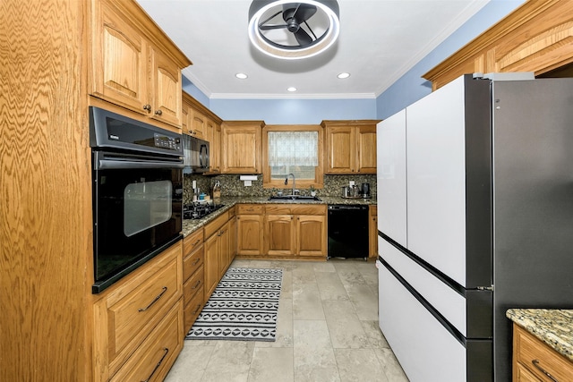 kitchen featuring ornamental molding, dark stone counters, tasteful backsplash, a sink, and black appliances