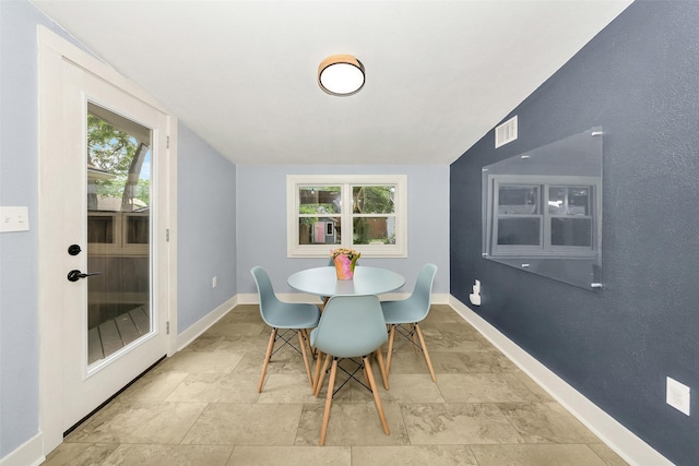 dining space with stone tile floors, baseboards, and visible vents