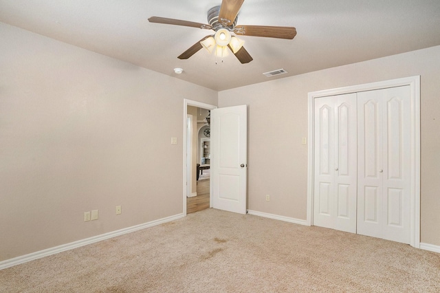 unfurnished bedroom featuring a closet, visible vents, ceiling fan, carpet floors, and baseboards