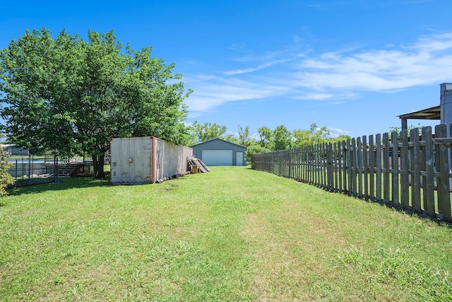 view of yard with a fenced backyard, an outdoor structure, a garage, and a shed