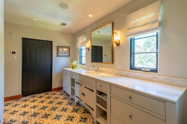 bathroom featuring visible vents, baseboards, recessed lighting, and vanity