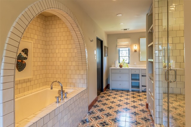 bathroom featuring vanity, baseboards, a stall shower, visible vents, and a garden tub