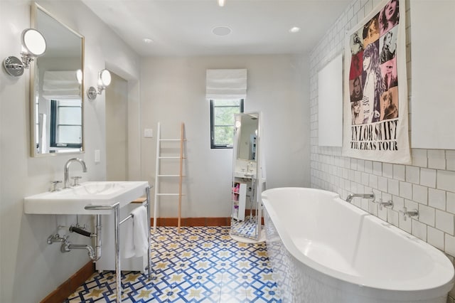 6955 Lakewood Blvd, Dallas, TX 75214 - bathroom with tile patterned floors, a freestanding tub, a sink, baseboards, and backsplash