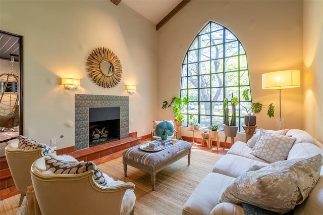 living area with a tiled fireplace, a wealth of natural light, and high vaulted ceiling
