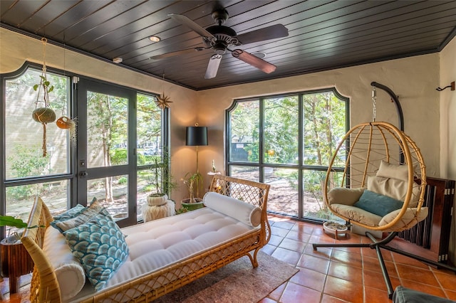 sunroom / solarium with wooden ceiling, a ceiling fan, and tile patterned flooring