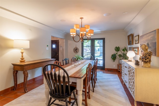 dining room with a chandelier, crown molding, light tile patterned floors, and baseboards