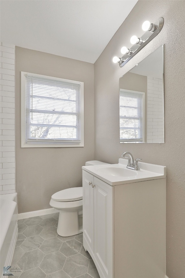 4158 Russell Ave, Abilene, TX 79605 - bathroom with a wealth of natural light, tile patterned flooring, vanity, and toilet